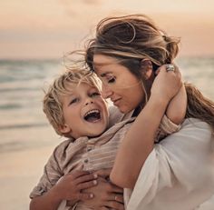 a woman holding a child on the beach