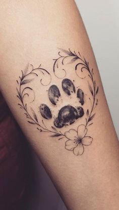 a dog paw tattoo on the left forearm and right arm, with flowers around it