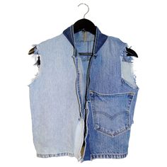 a blue jean vest hanging on a hanger with some torn up jeans and buttons