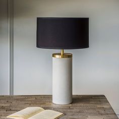 a lamp that is sitting on top of a table next to a book and some bread