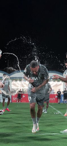 two soccer players are playing with water on the field