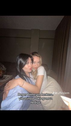 two young women hugging each other on a bed