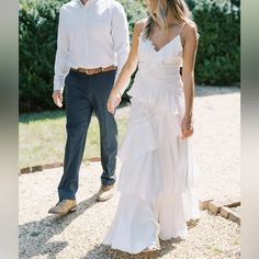 a man and woman walking down a path holding hands