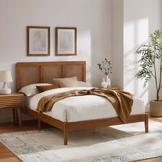 a bedroom with a bed, nightstands and pictures on the wall above it is shown