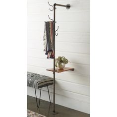 a coat rack with two coats hanging from it's sides and a bench on the other side