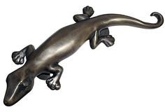 a metal lizard figurine on a white background