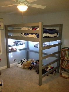 there is a bunk bed in the room with stuffed animals on the floor and bookshelves