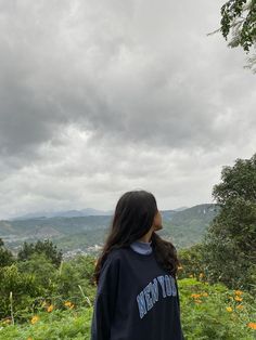 a woman standing on top of a lush green hillside