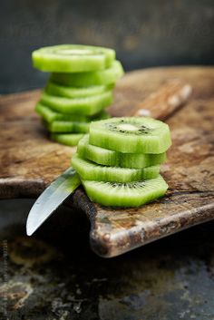 sliced cucumber slices on a cutting board with a knife by lumina for stocks