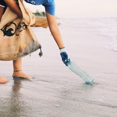 a woman is cleaning the sand with a brush