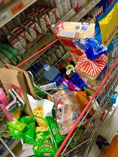 a shopping cart filled with lots of food and condiments in a grocery store