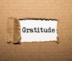 a piece of cardboard with the word gratitude appearing through it