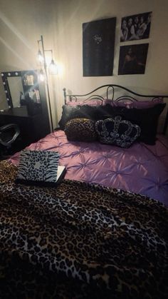 a leopard print comforter on a bed in a bedroom with pink sheets and pillows