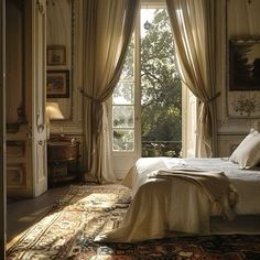 a large bed sitting under a window next to a rug on top of a floor