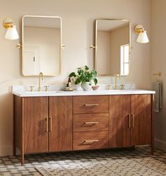 a bathroom with two sinks and mirrors on the wall next to a checkered rug