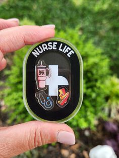 a person holding up a badge with the words nurse life and medical symbols on it