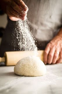 a person is sprinkling flour on top of a doughnut