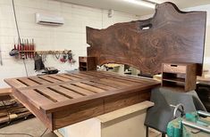 a large wooden bed frame sitting on top of a workbench in a shop