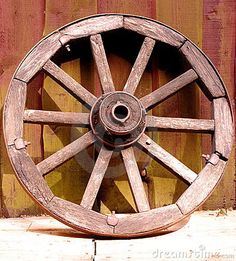 an old wooden wagon wheel on the ground