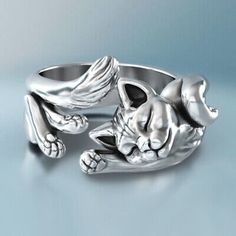 a silver cat ring with wings on it's head and paws in the air