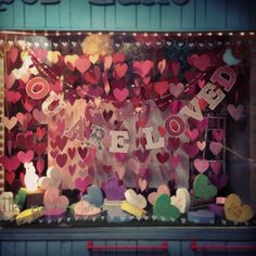 a window display with lots of hearts and letters on the windowsill in front of it