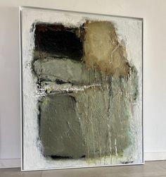 an abstract painting on the wall with white and grey colors, including black and green