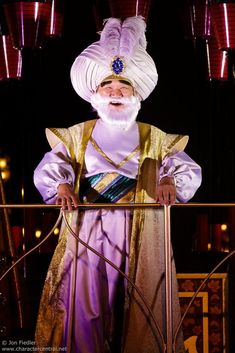 a man with a white beard and turban standing next to a metal railing