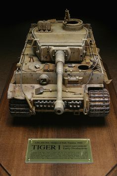 an old model tiger tank on display in a museum case with a plaque describing it's history