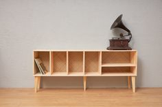 an old record player sits on top of a wooden shelf next to a bookcase