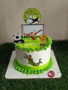 a soccer themed birthday cake on the grass with a goalie and ball in the background