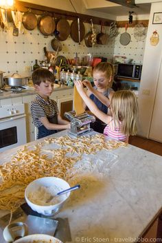 two children are making pasta in the kitchen