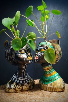 two vases with plants in them sitting on a table