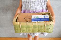 a person holding a basket with boxes in it and a box on the other side