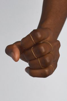 a person holding out their hand with two gold rings on it's thumb and fingers