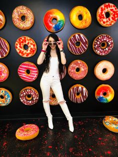 a woman standing in front of a display of donuts