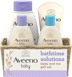 two bottles of baby lotion sitting in a basket next to a sign that says,'bathtime solutions baby and me gift set '