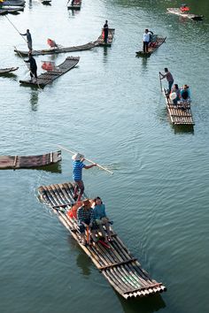 several people are rowing in small boats on the water