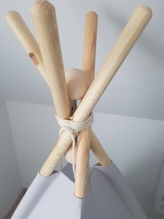 three wooden sticks tied to each other on top of a white surface with no one around them