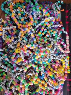 a bunch of beads that are sitting on a table with words written in them and some type of string attached to the bead