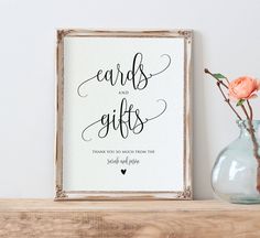 a sign that says cards and gifts on it next to a vase with flowers in it