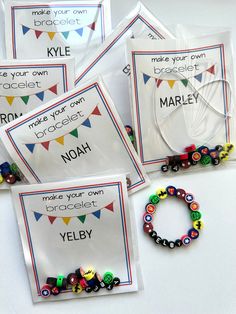 four bags filled with different colored beads on top of a white table next to each other