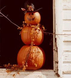 three pumpkins are stacked on top of each other in front of an open window