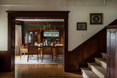 a dining room with wooden floors and stairs