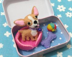 a small toy dog sitting in a pink box