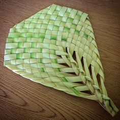 a piece of green woven material sitting on top of a wooden table