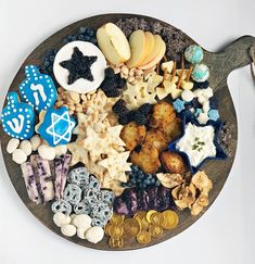 a wooden platter filled with lots of different types of cookies and other food items