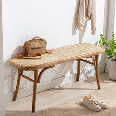 a wooden bench sitting in front of a wall with a bag on top of it