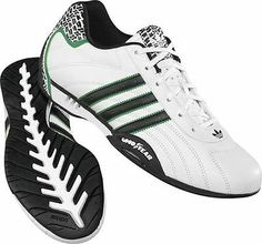 a pair of white and black shoes with green accents on the soles, side view