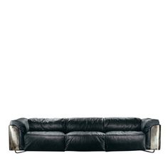 a black leather couch sitting on top of a white floor