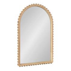 an oval mirror with scalloped edges and a wooden frame